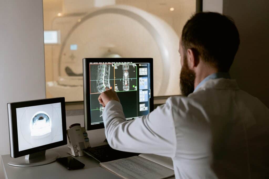 Medical Radiotech looking at CAT Scan on computer screen