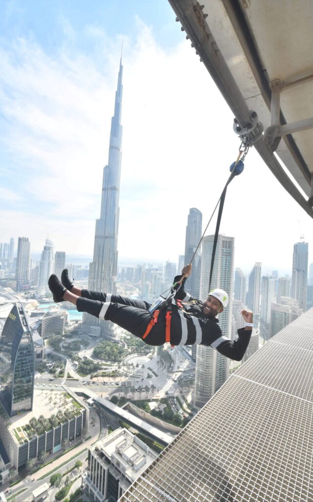 Wylie swinging on skyscraper at the Sky Views Edge Walk in Dubai, United Arab Emirates