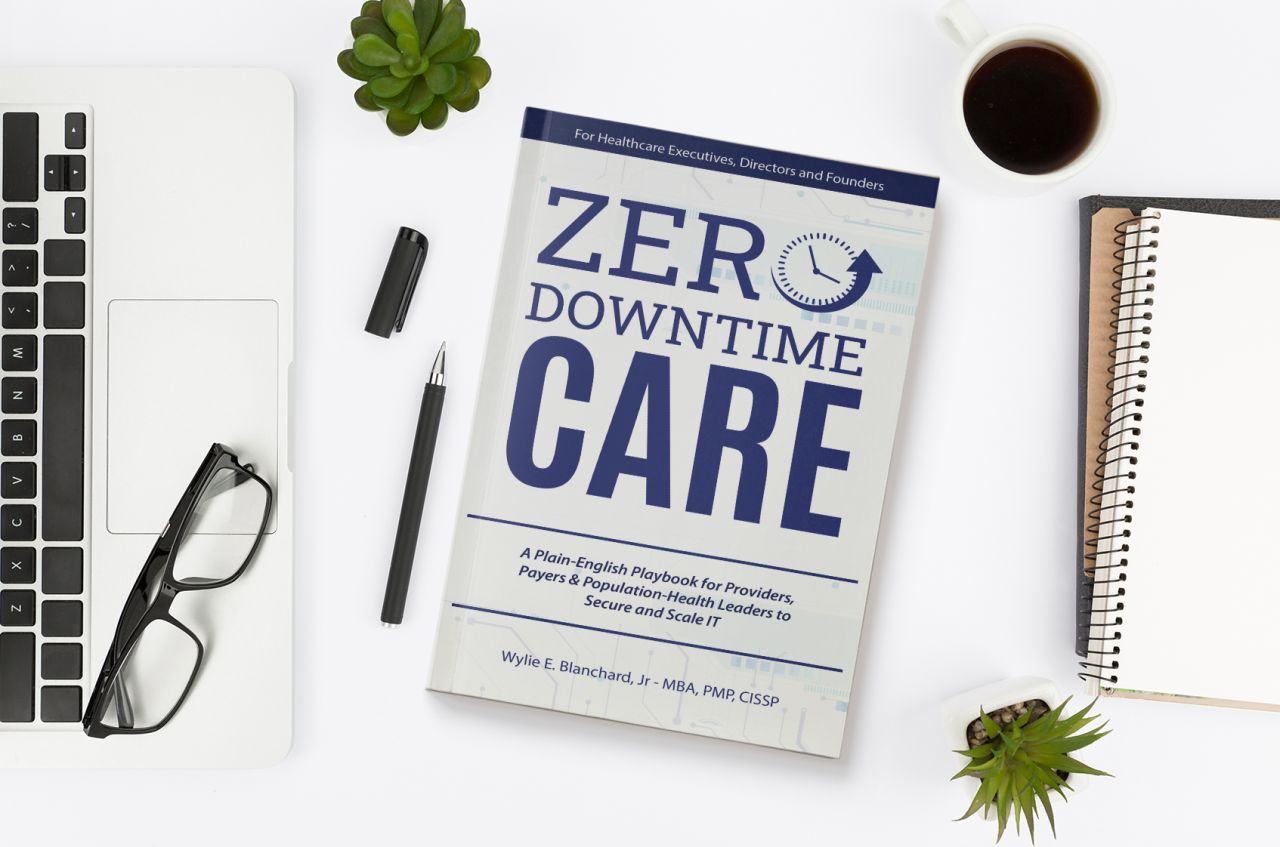 Book on desk next to laptop and notepad. Book cover text: Zero-Downtime Care A Plain-English Playbook for Providers, Payers & Population-Health Leaders to Secure and Scale IT. By Wylie E. Blanchard, Jr